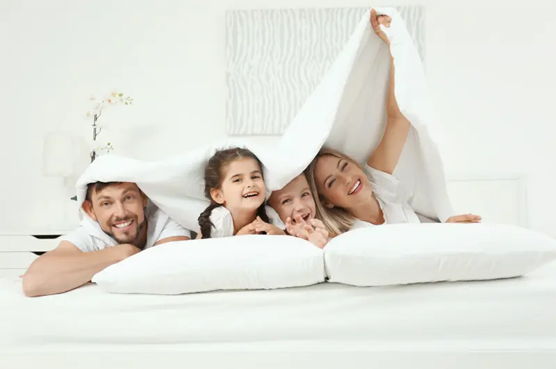 Family covered by blankets in Bloomfield Hills home